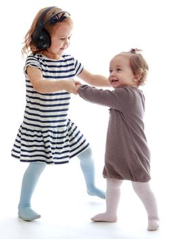 Two little girls play holding hands.Isolated on white background.