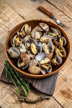 Steamed cooked shells Clams vongole in a wooden plate. wooden background. Top view.