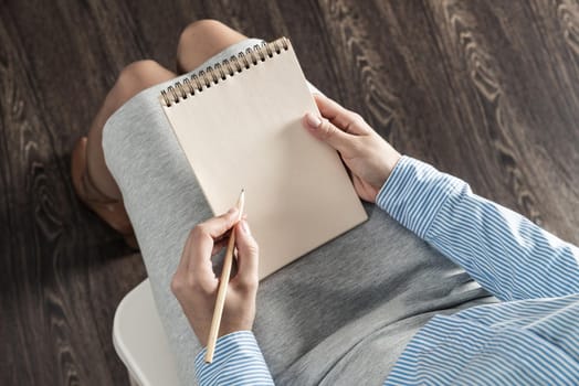 close-up a female hands with notebook and pencil