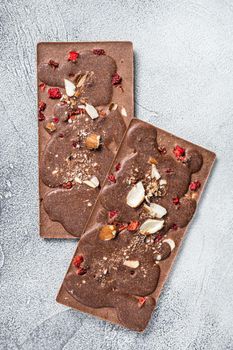 Craft homemade chocolate bars on kitchen table. White background. Top view.