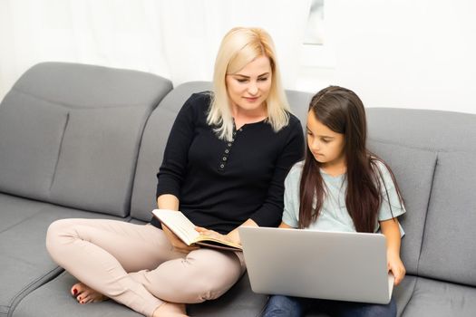 mother and daughter doing homework with a tablet