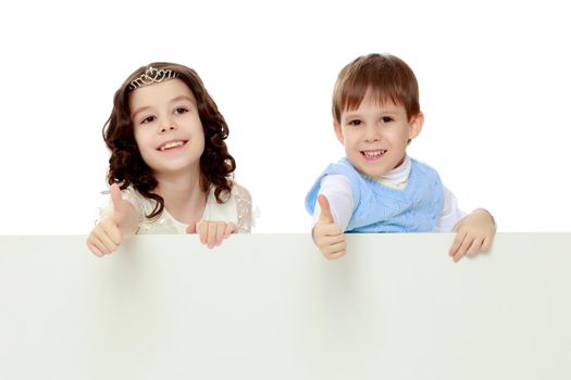 A boy and a girl peeping from behind the white banner.Children show a gesture all okay.Isolated on white background.