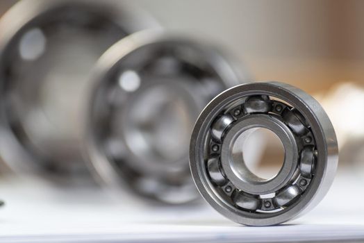 Three various ball bearings lying on table. Automotive spare part sale company. Heavy industry engineering company. Machinery designing and manufacturing. Steel details for engine mechanisms.