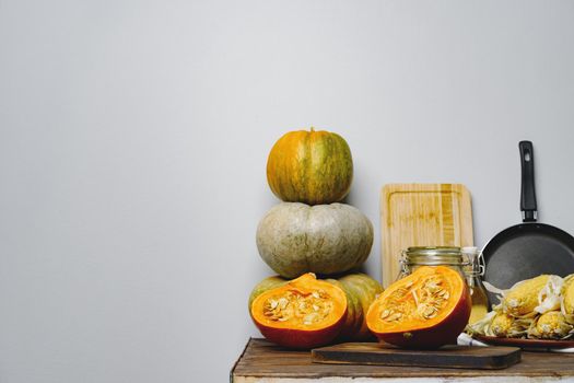 Pumpkins on kitchen table against grey wall close up