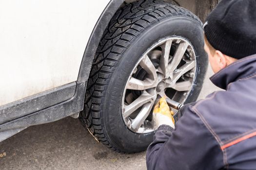 Car mechanic removing wheel nuts to check brakes