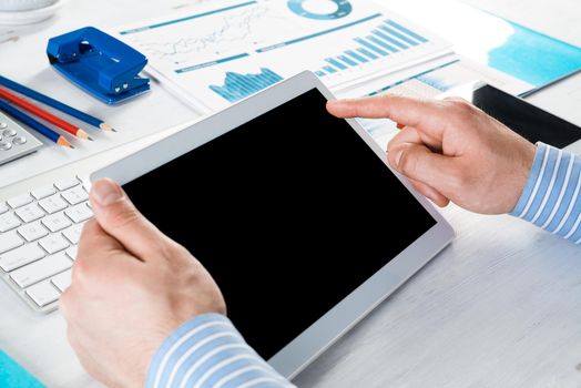 close-up of men's hands with a computer tablet. Businessman works in the office