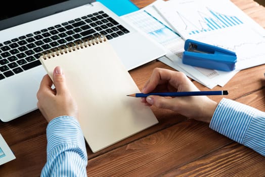 close-up, female hands with notebook and pencil. Business woman working at the table in the office