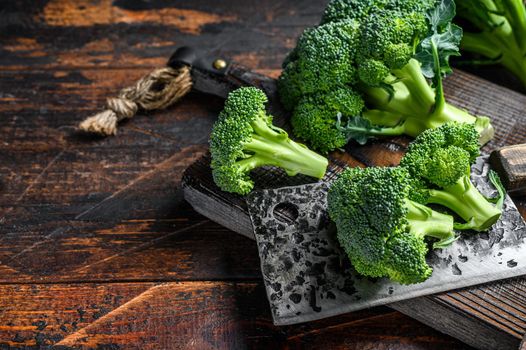 Raw Cut broccoli on a cutting board. Dark wooden background. Top view. Copy space.