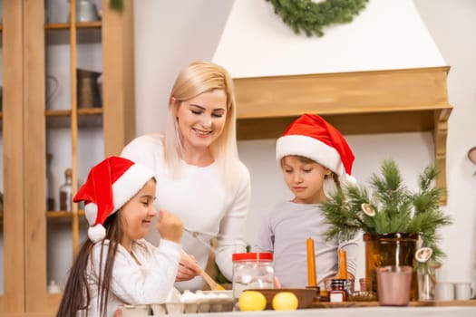 Two girls dressed in red hats are preparing cookies, gingerbread for the New Year holiday, Christmas. Cut out cookies.