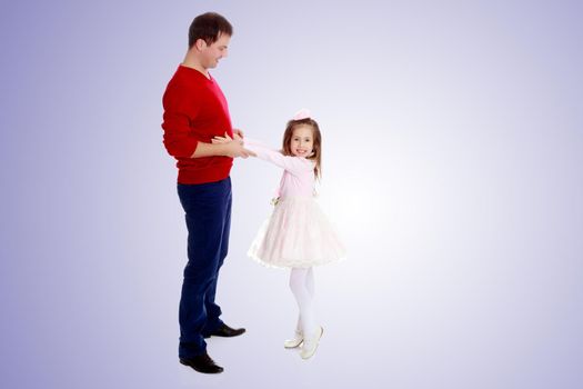 Cute little long-haired girl in a smart pink dress , reaches out to his dad.Purple gradient background.