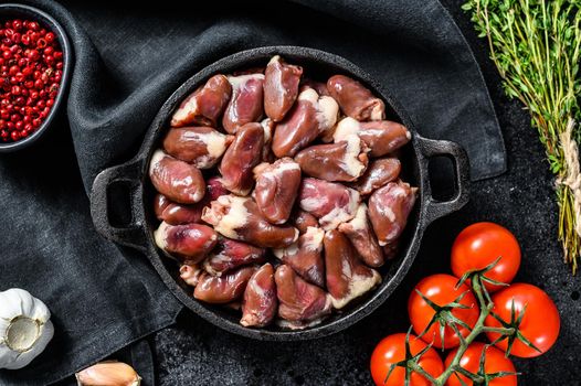 Fresh chicken hearts. Raw offal. Black background. Top view.