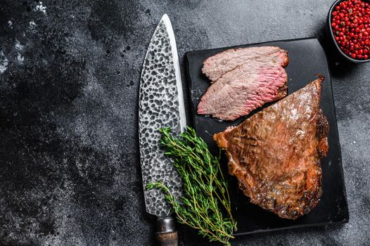 Roast beef tri tip steak bbq. Black background. Top view. Copy space.