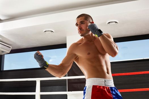 Boxer in grey gloves warming up in the gym. naked torso.