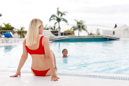 Summer in the city. Happy young woman near swimming pool.