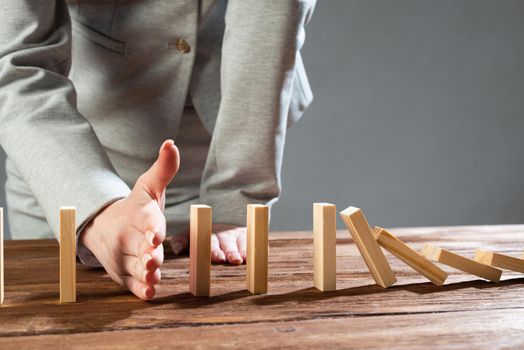 Business woman hand stop domino effect. Operative business solution, strategy and successful intervention. Life insurance company presentation with wooden blocks. Protection from economic crisis.