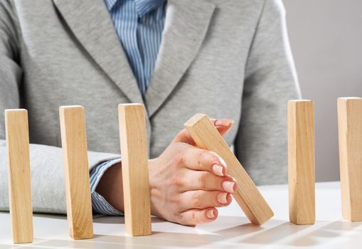 Business woman hand stop domino effect. Operative business solution, strategy and successful intervention. Life insurance company presentation with wooden blocks. Protection from economic crisis.