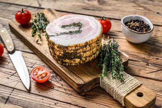 Pancetta, typical italian roll raw bacon. Wooden background. Top view.