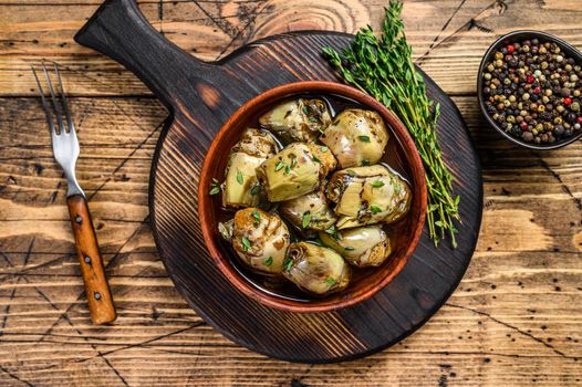 Artichoke hearts pickled in olive oil. wooden background. Top view.