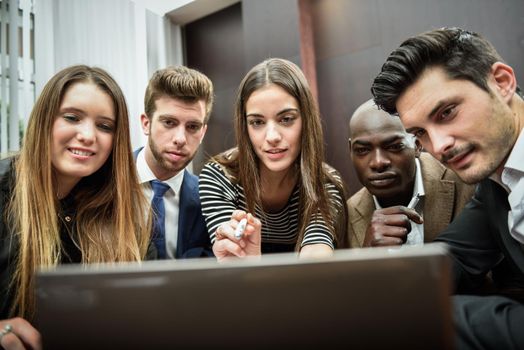 Businesspeople, teamwork. Group of multiethnic busy people looking at a laptop computer