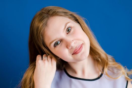Portrait of a blonde girl on a blue background