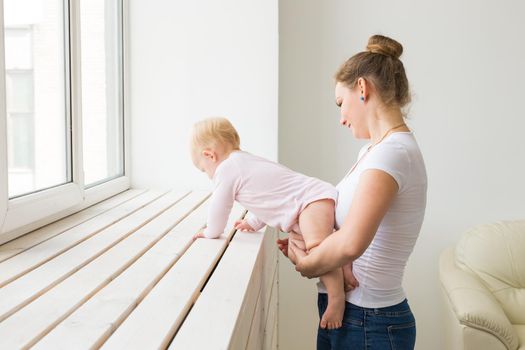 Childhood, family and motherhood concept - Mother with her baby playing at living room.