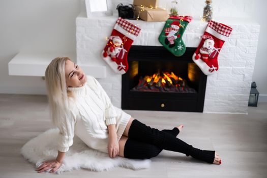 Happy young lady by the fireplace. Christmas New year concept.