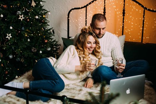 caucasian girl and her boyfriend watch a film in christmas atmosphere