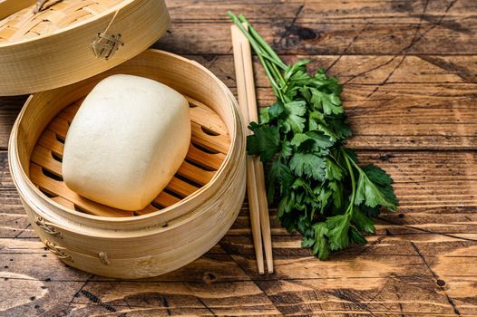 Chinese Steamed Buns in traditional bamboo steamer. Wooden background. Top view. Copy space.