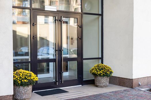 The front door of a office block, reflecting buildings in the glass.