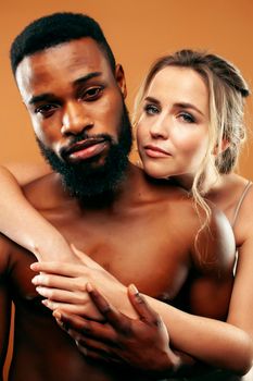 Young pretty couple diverse races together posing sensitive on brown background, lifestyle people concept close up