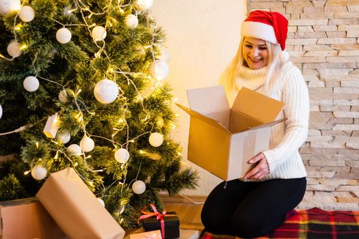Happy young woman opening a Christmas present box