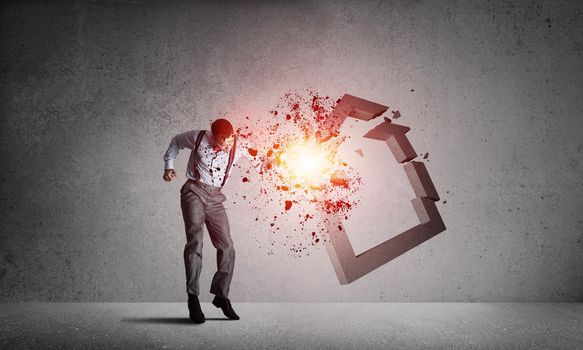 Determined businessman jumping and breaking with fist house concrete figure