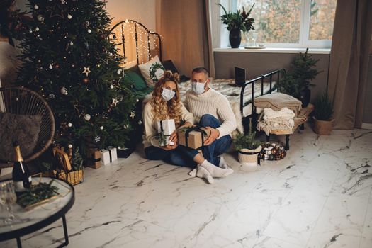 Caucasian woman and her husband relaxes in the bedroom in christmas atmosphere together.