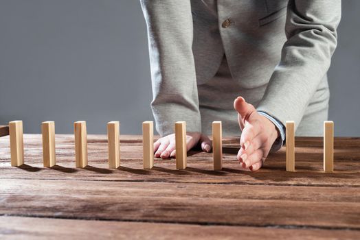 Business woman hand stop domino effect. Operative business solution, strategy and successful intervention. Life insurance company presentation with wooden blocks. Protection from economic crisis.