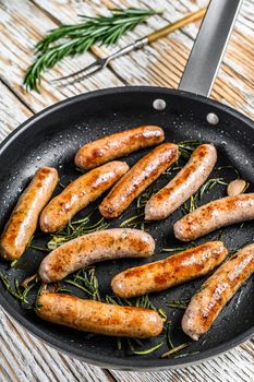 Homemade sausages fried in a pan, beef and pork meat. wooden background. Top view.
