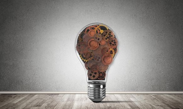 Glass lightbulb with multiple gears inside placed in empty room with grey wall on background. 3D rendering.