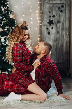 Caucasian woman and man relaxes on the floor in the living room in christmas atmosphere together.