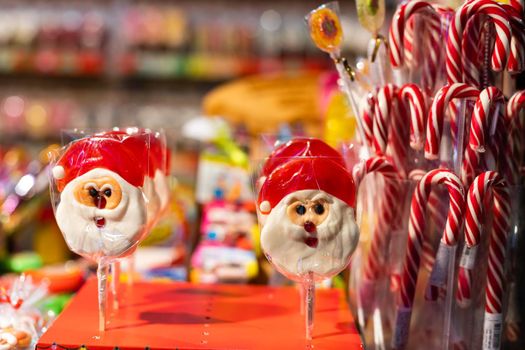 Two lollipops in the shape of Santa Claus on a stick in a transparent film closeup.
