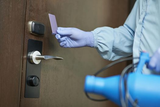 Close up of man protective gloves when going to enter the room and disinfect. Coronavirus and quarantine concept