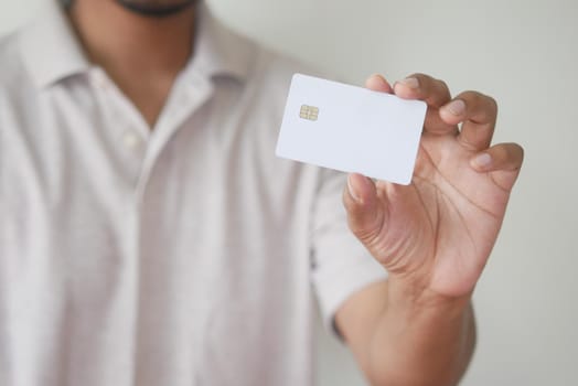 Man in casual dress showing credit card.