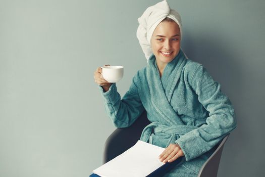 Girl in a studio. Lady in a blue bathrobe. Woman with a documents