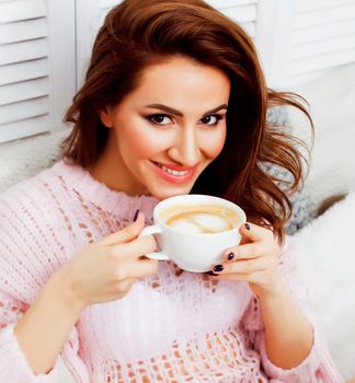 young pretty brunette girl laying in cozy bed with coffee wearing wool winter sweater happy smiling, lifestyle people concept close up