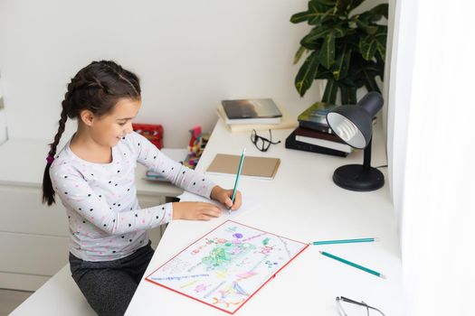 a child girl doing homework writing and reading at home