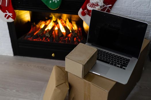 Laptop computer with white blank empty screen on Merry Christmas with presents gifts. Ecommerce website online shopping delivery ads.