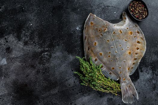 Raw flounder flatfish fish on marble board with thyme. Black background. Top view. Copy space.