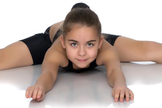 A little girl performs a gymnastic twine. The concept of fitness and sports. Isolated on white background.