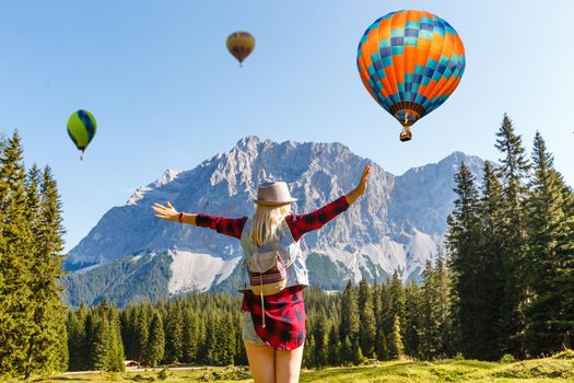 Sunset over forest mountain with hot air balloon.