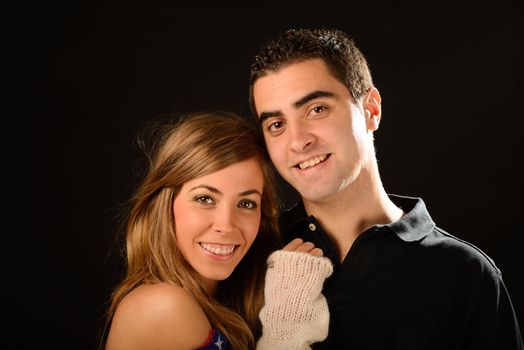 Portrait of a happy couple smiling at camera on black background