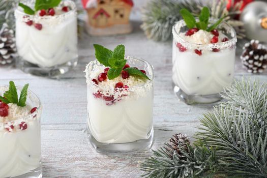 White Christmas mojito made from liqueur, tequila, coconut milk with pomegranate seeds, coconut flakes and refreshing mint.