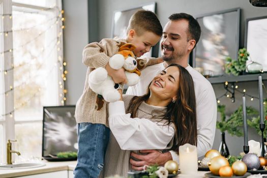 A portrait of happy family in the kitchen decorated for Christmas holidays